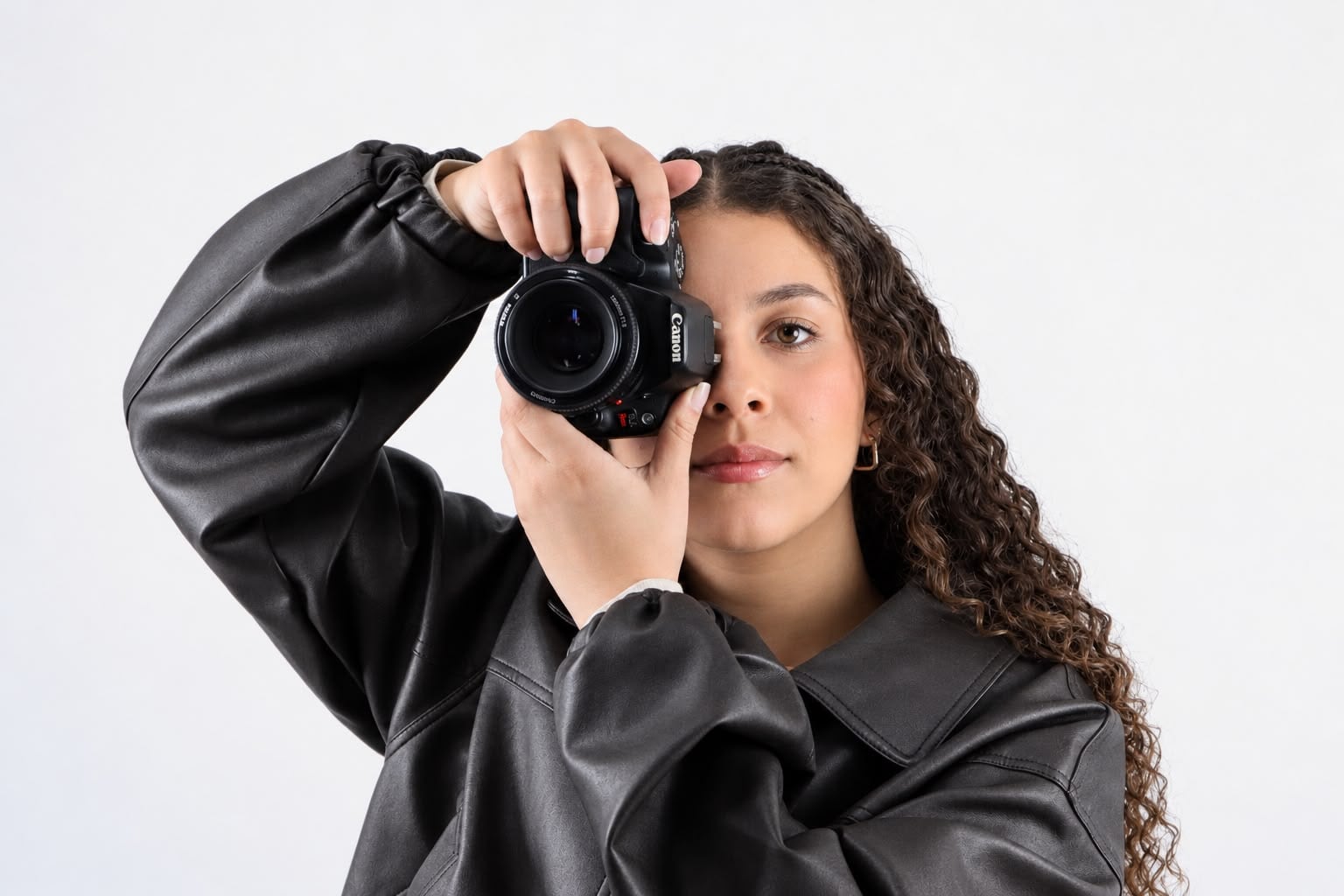 A fotógrafa Eduarda segurando a câmera em frente ao rosto